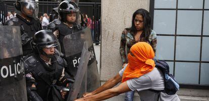 A street protester tries to take a shield from the riot police in Caracas.