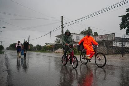 People under the rain ahead of the arrival of Hurricane Ian in Coloma, Cuba on Monday.