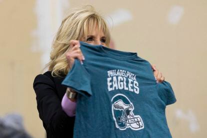 First lady Jill Biden holds up a Philadelphia Eagles shirt while sorting children's clothes at the FEMA State Disaster Recovery Center in Bowling Green, Ky., Jan. 14, 2022.