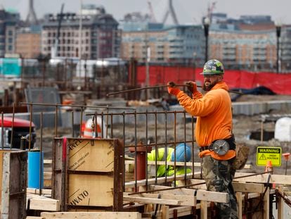 A construction worker prepares a recently poured concrete foundation, Friday, March 17, 2023, in Boston.