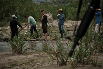 People work on the trails near the Táchira river while the Colombian army patrols the area, on March 29.