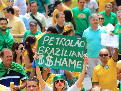 A woman holds up a sign reading “Brazilian Oil $$hame” during Sunday's protests held against Rousseff’s policies.