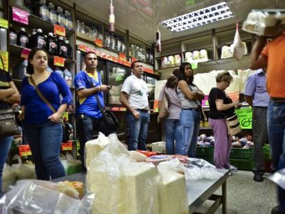 Customers line up to pay for food at a checkout in a Caracas supermarket.  