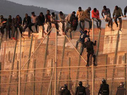 Immigrants attempt to jump the Melilla border fence.