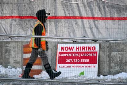 A worker passes a hiring sign at a construction site, Wednesday, Jan. 25, 2023, in Portland, Maine.