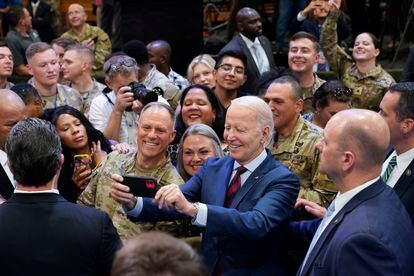 President Joe Biden takes a selfie during a visit to Fort Liberty, N.C.
