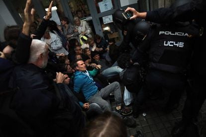 National Police officers remove members of the public from the Jaume Balmes school in Barcelona.