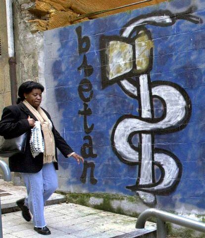 A woman walks past an ETA mural in Eibar on Friday.