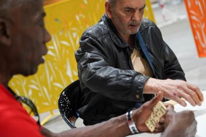 Heliodoro (left) and Jesús play dominoes in the homeless shelter in Ifema’s Pavilion 14.
