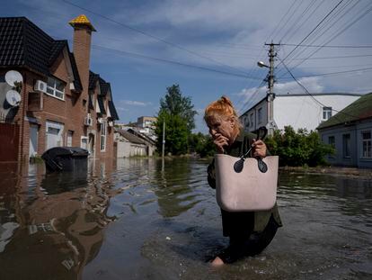 A local resident makes her way through a flooded road after the Russian troops blew the Kakhovka dam overnight, in Kherson, Ukraine, June 6, 2023.