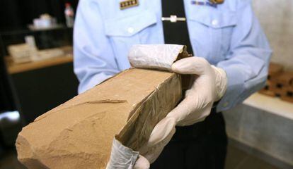 An officer with a heroin package seized during a drug haul in Catalonia in 2014.