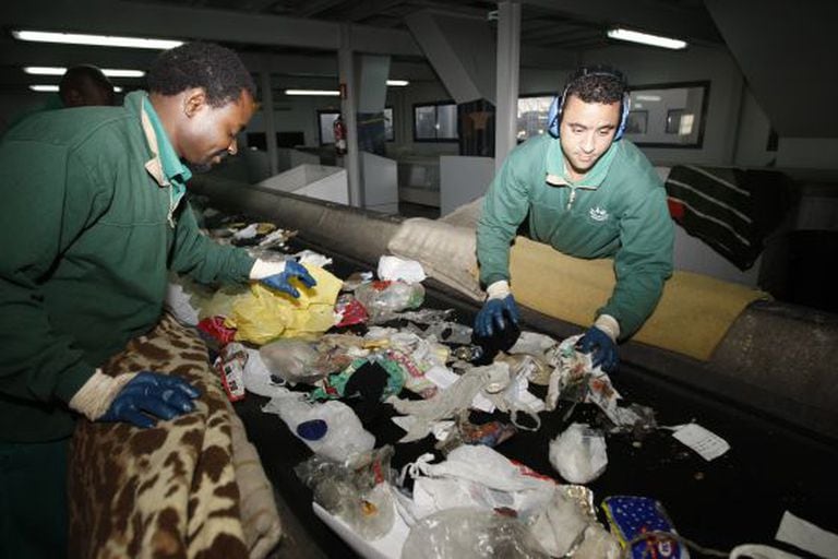 Two workers manually separate garbage at the Valdemíngomez waste plant.