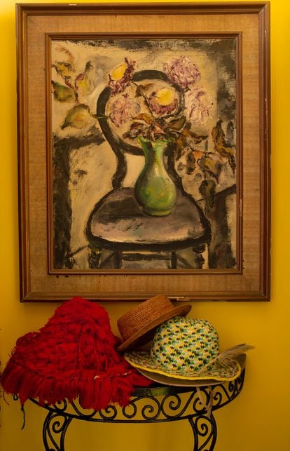 Several hats Beaufre acquired in Bali, France, Morocco and other countries, under a picture his mother painted.