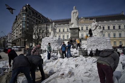 Dozens of volunteers sandbag a monument to Princess Olga in the center of Kyiv to protect it from a possible attack. 
