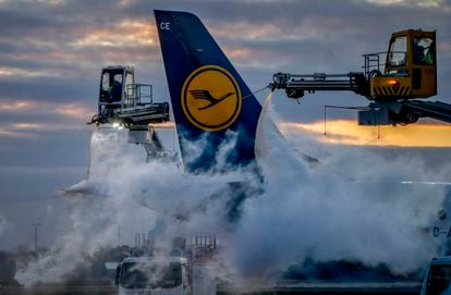 A Lufthansa aircraft is de-iced at the airport in Frankfurt, Germany, Sunday, Feb. 26, 2023.