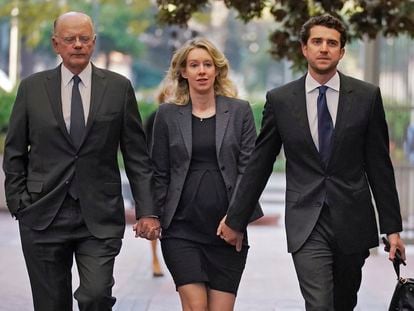 Former Theranos CEO Elizabeth Holmes, center, arrives at federal court with her father, Christian Holmes IV, left, and partner, Billy Evans, in San Jose, Calif., Monday, Oct. 17, 2022.