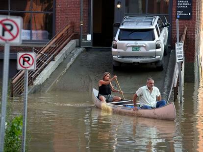 Two residents use a canoe to remove surgical supplies from the flood-damaged center, on July 11, 2023, in Montpelier, Vermont.