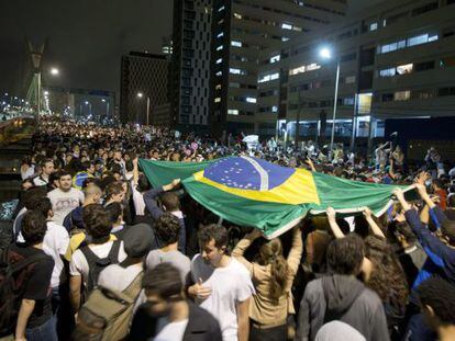 Students lift a Brazilian flag during Monday night&#039;s protest in S&atilde;o Paulo.