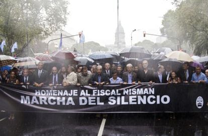 People march under heavy rain showers in Buenos Aires on Wednesday.