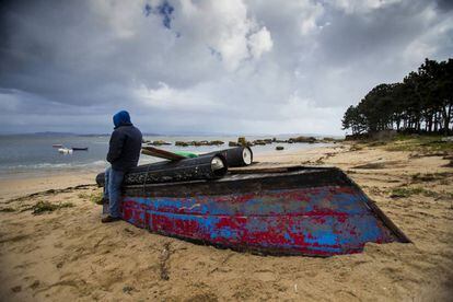 A poacher on the Arousa estuary leans on a boat used for the nightly raids.