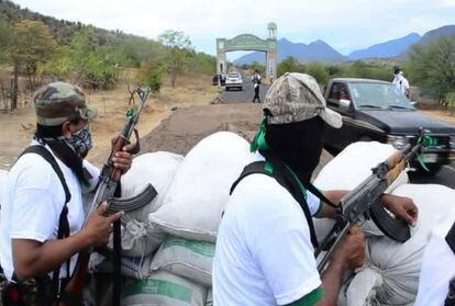 Self-defense forces stand guard at the entrance to Churumuco.