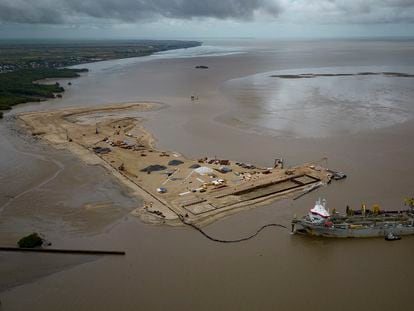 A ship builds an artificial island to create a coastal port to facilitate offshore oil drilling at the mouth of the Demerara River.