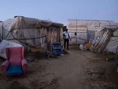 A field worker walks between shacks at the makeshift camp in Lepe.