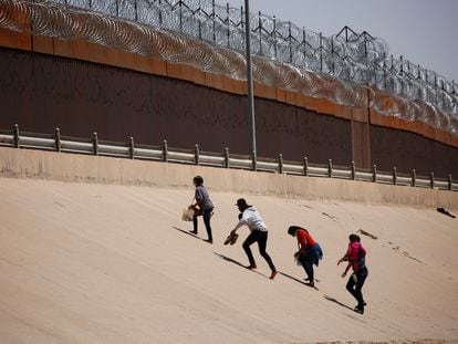 Migrantes caminan hacia el muro fronterizo luego de cruzar la frontera en El Paso, Texas