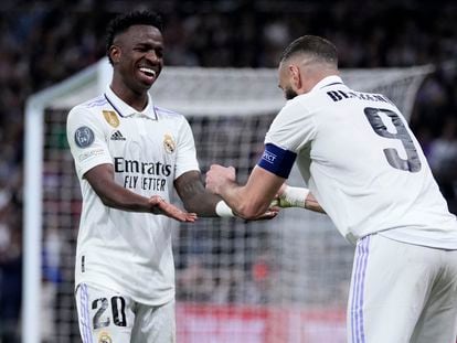 Real Madrid's Karim Benzema, right, celebrates with teammate Vinicius Junior after scoring his sides first goal during their Champions League, round of 16, second leg soccer match against Liverpool at the Santiago Bernabeu stadium in Madrid, Spain, Wednesday, March 15, 2023.