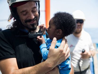 A rescue worker with a baby on the Aquarius.