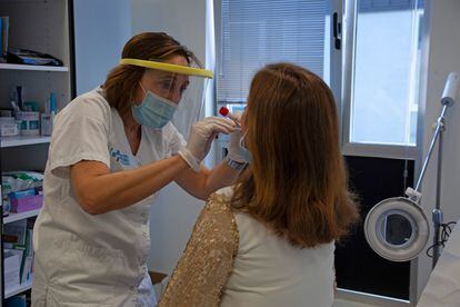 A doctor from the sentinel network in La Rioja, Spain, takes a sample from a patient.