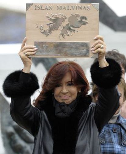 Argentinean President Cristina Fernández de Kirchner holds up a plaque before delivering a speech in 2012.