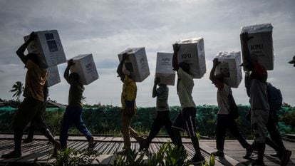 Volunteers carry cardboard ballot boxes to polling stations in Asmat, in southern Indonesia's Papua province, on February 13.