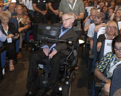 Stephen Hawking arrives onstage with Spanish police standing by.