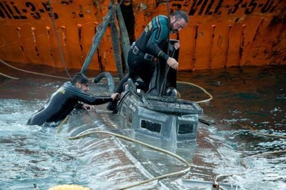 Spanish Civil Guard divers stand over the “narco-submarine.”