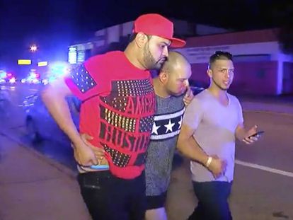 A man injured in the nightclub attack is helped by friends.