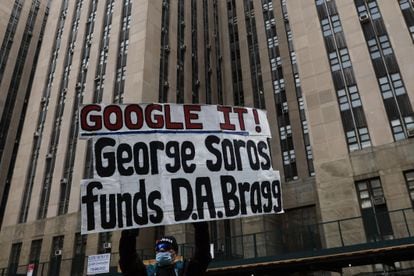 A protestor holds a placard against billionaire investor George Soros outside Manhattan Criminal Court in New York City, on March 22, 2023.