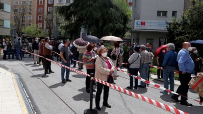People wait in line for the Covid-19 vaccine outside Gregorio Marañón Hospital in Madrid.