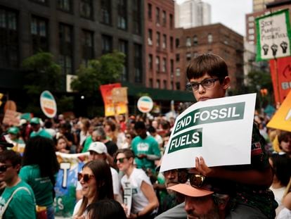 Oliver Moore, 7, of Montpelier, Vermont, listens to a speaker during a rally to end the use of fossil fuels, in New York, Sunday, Sept. 17, 2023.
