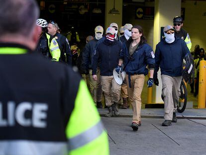 Police escort members of the Patriot Front from a parking garage, after they held a march near Capitol Hill, in Washington, in 2020.