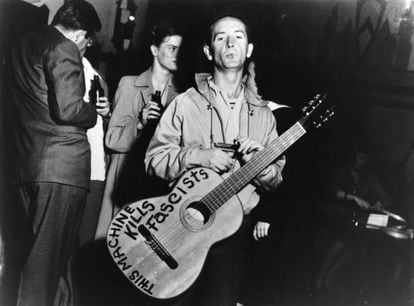 American folk musician Woody Guthrie with an anti-fascist message on his guitar