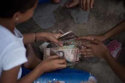 Children playing with bolívar banknotes.