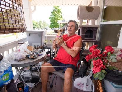 Ben Gallegos sits on the porch of his family's home in the Globeville neighborhood with his dog, Coca Smiles, as the daytime high temperature soars toward triple digits, on July 27, 2023, in Denver.