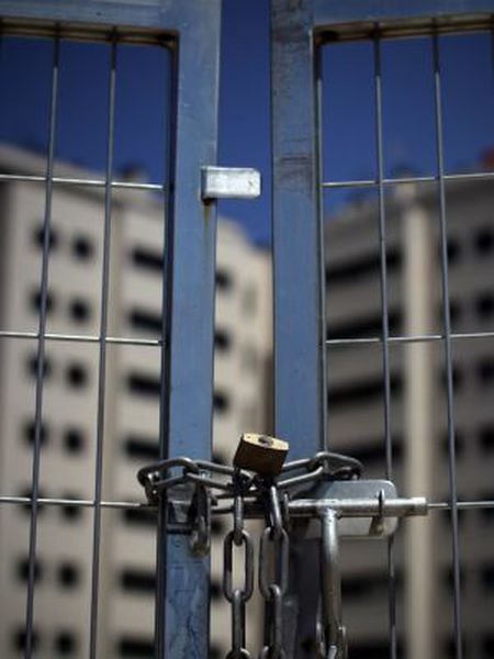 A chained gate blocks access to a new housing development in Madrid.