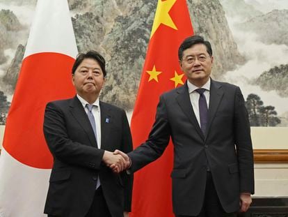 Japanese Foreign Minister Yoshimasa Hayashi, left, shakes hands with his counterpart Qin Gang at the Diaoyutai State Guest House in Beijing Sunday, April 2, 2023. (Kyodo News via AP)