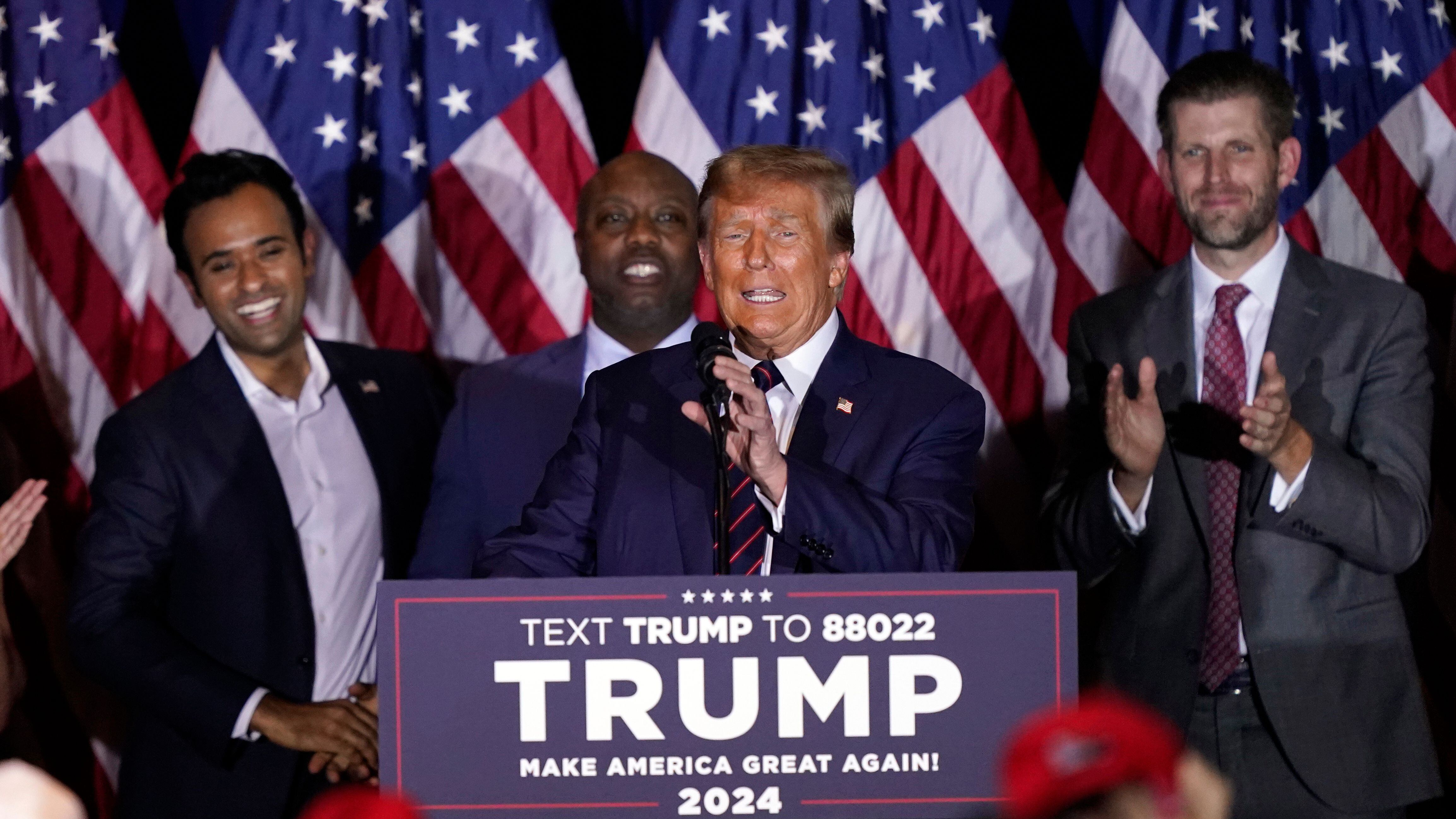 Donald Trump, after the New Hampshire primary, with Vivek Ramaswamy (left) and Tim Scott, behind the former president.