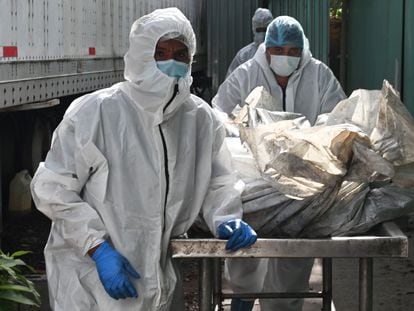 Forensic employees transport the corpses of several of the 46 dead women during a fire following a brawl between inmates of the Women's Social Adaptation Center (CEFAS) prison in Tegicugalpa, on June 21, 2023.