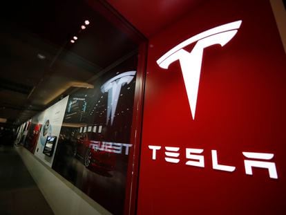 A sign bearing the Tesla company logo is displayed outside a Tesla store in Cherry Creek Mall in Denver, Colorado, Feb. 9, 2019.