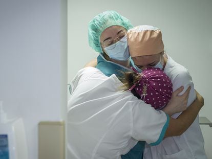Three nurses at the Quirónsalud Sagrado Corazón hospital hug after the last coronavirus patient is transferred out of the intensive care unit.