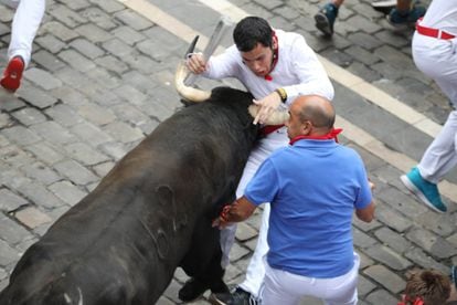 A bull catches a runner on Friday morning in Pamplona.